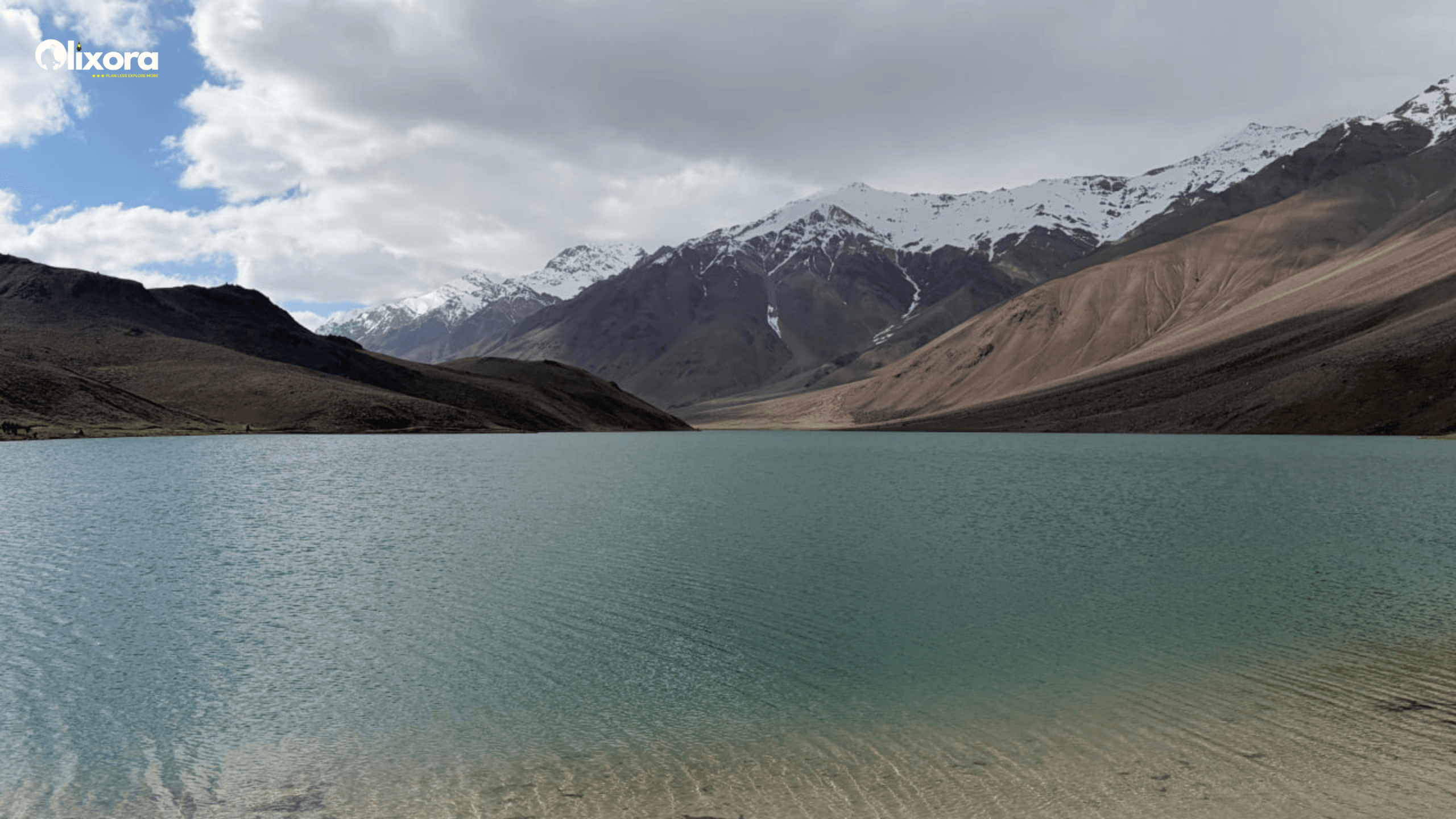 The crystal-clear, crescent-shaped waters of Chandratal Lake perfectly mirroring the barren mountain ridges of Lahaul